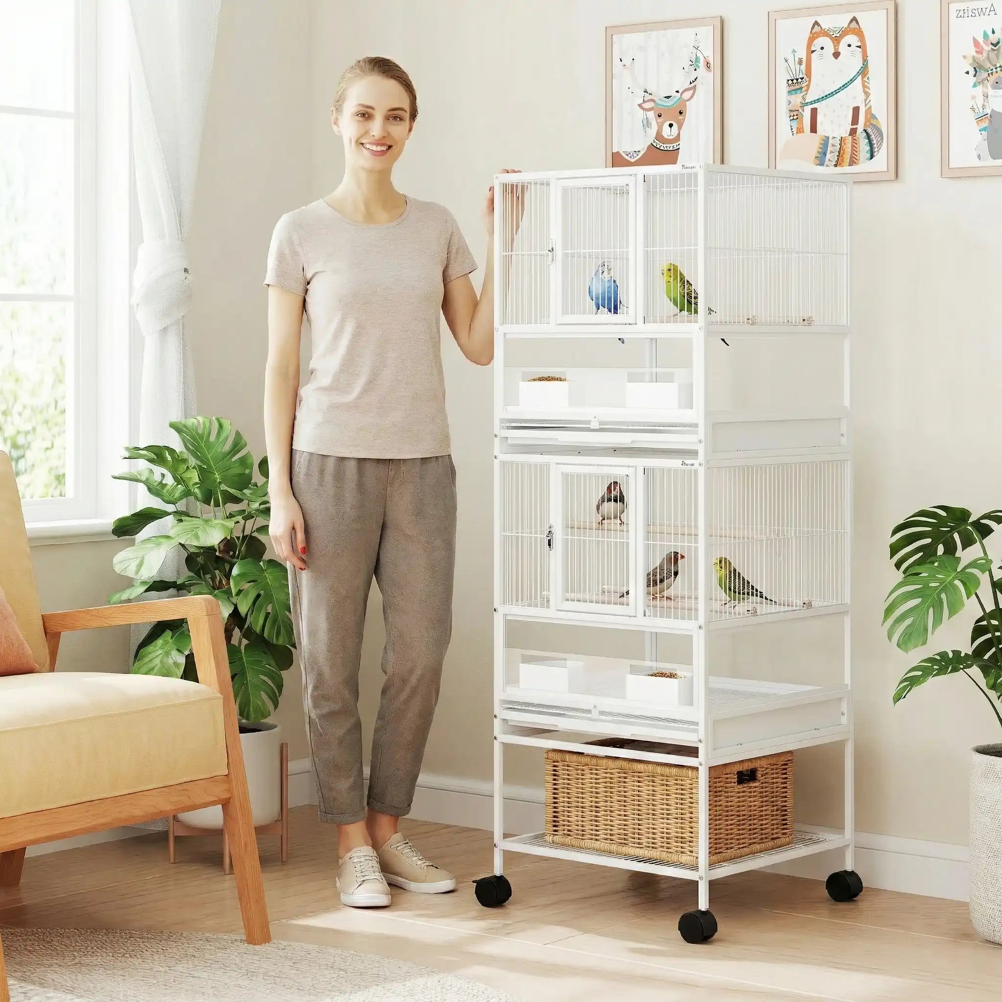 Femme souriante présentant une grande cage oiseaux avec séparation et espace de rangement sur roulettes blanche dans un salon